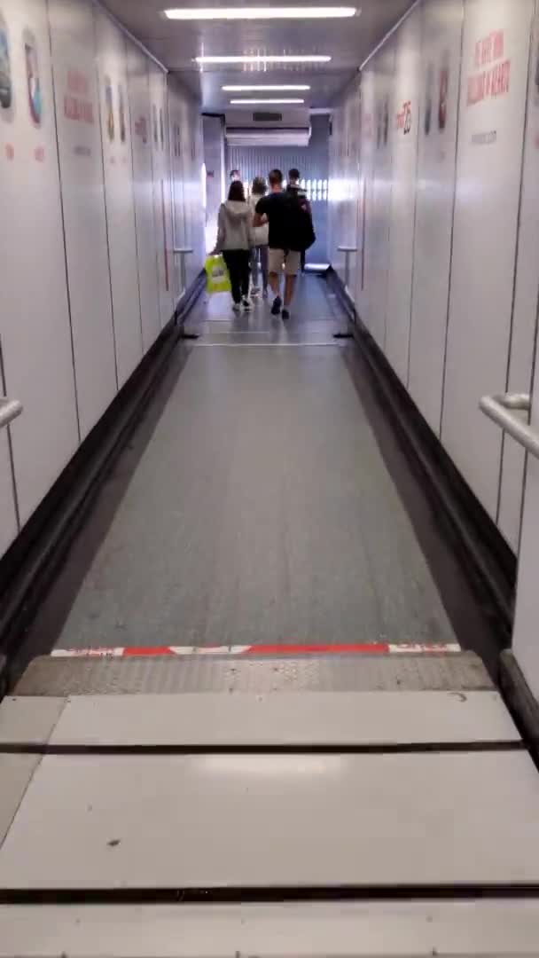 터어 키 의 안 탈리아 공항 비행기에 연결 된 제트 다리 안에서 걷고 있는 관광객들 — 비디오