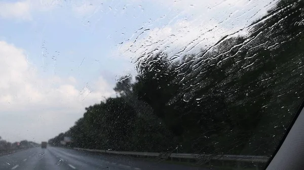 Vista para-brisa do carro de chuva salpicos e gotejamento — Fotografia de Stock