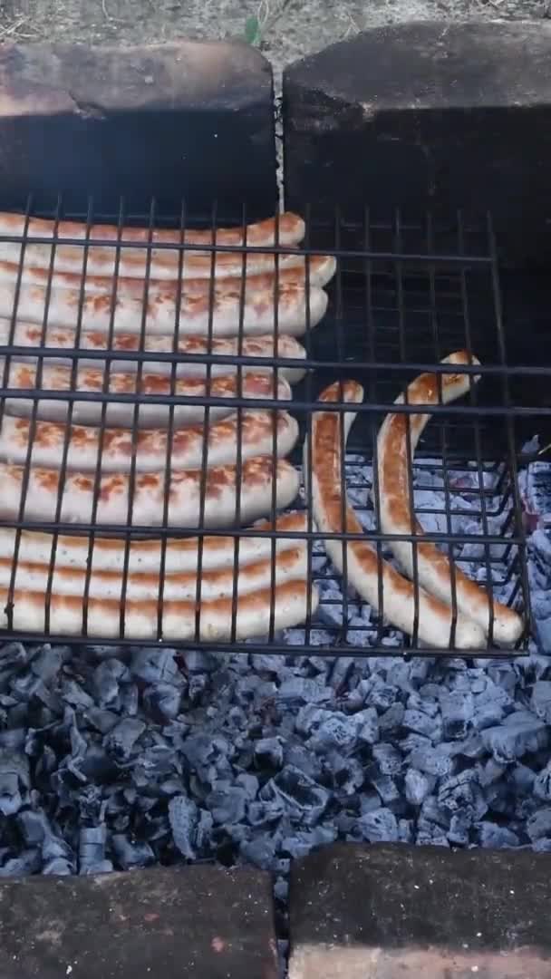 Fogão rústico de pedra no chão com carvão em chamas e grelha de salsichas assadas — Vídeo de Stock