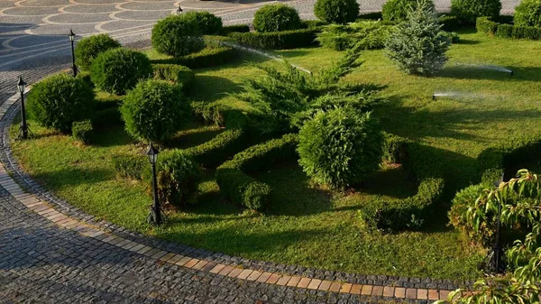 A kerti locsolók elforgatják és permetezik a vizet a parkosított kertbe — Stock Fotó