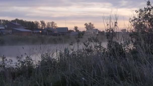 Mist over de rivier in de buurt van dorp — Stockvideo