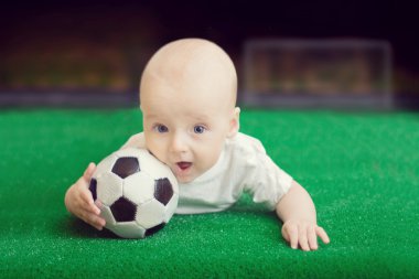 Küçük çocuk ile topu çim üzerinde yalan