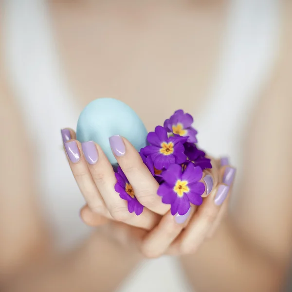 Женщина держит в руках пасхальное яйцо — стоковое фото