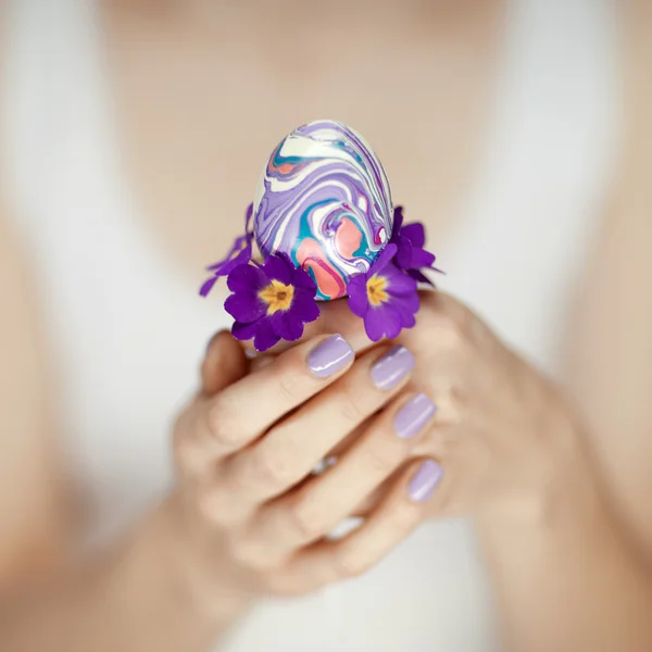 Manos de mujer sosteniendo huevo de Pascua — Foto de Stock