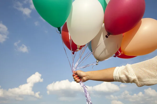 Frauenhand mit bunten Luftballons — Stockfoto