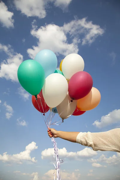 Kadın el ile renkli balonlar — Stok fotoğraf