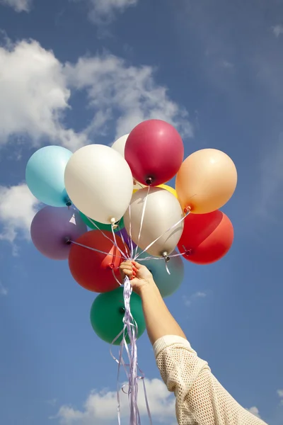 Kadın el ile renkli balonlar — Stok fotoğraf