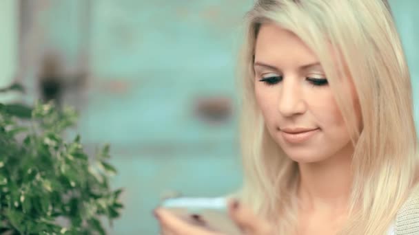 Красива жінка з мобільним телефоном в саду — стокове відео