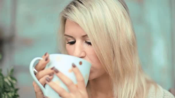 Güzel, sarışın genç kadın bahçede çay içme — Stok video