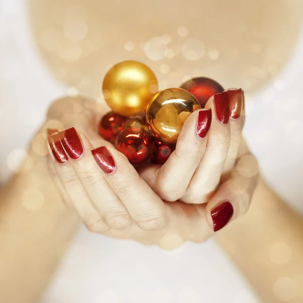 Belles mains de femme tenant des décorations de Noël — Photo