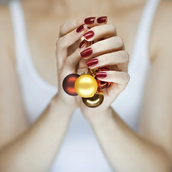 Beautiful woman hands holding christmas decorations — Stock Photo, Image