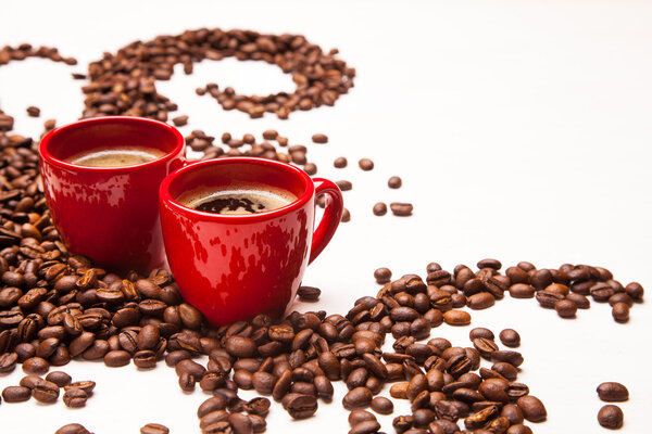 two red espresso cups with coffee beans