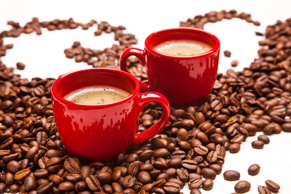 Duas xícaras de café vermelho com grãos de café — Fotografia de Stock