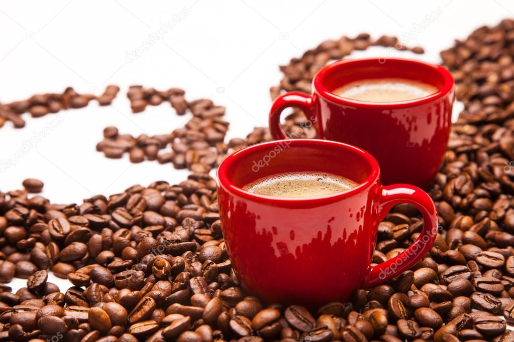 two red espresso cups with coffee beans