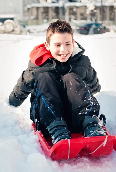 Gelukkig kind op de sneeuw dia — Stockfoto