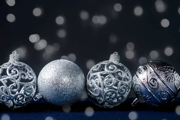 Christmas composition with silver ornaments. Bokeh lights. Copy space