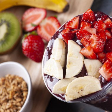 Yoğunlaştırılmış süt ve tropikal meyvelerle plastik bir fincanda dondurulmuş Brezilyalı. Amazon meyvesi..