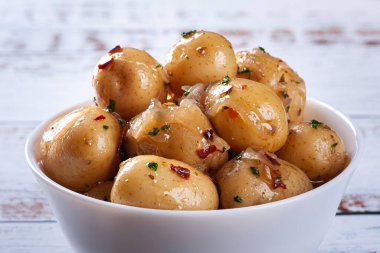 Beyaz kasede ev yapımı mini patates turşusu.