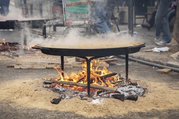 Paella valenciana cocinando a leña en pueblo español — Foto de Stock