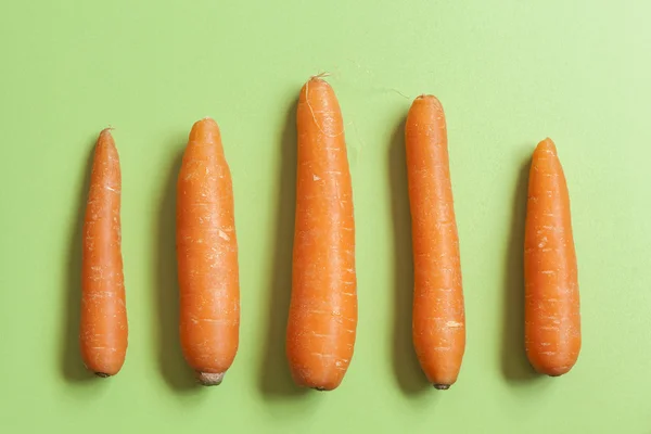 Satu set wortel di atas meja hijau — Stok Foto