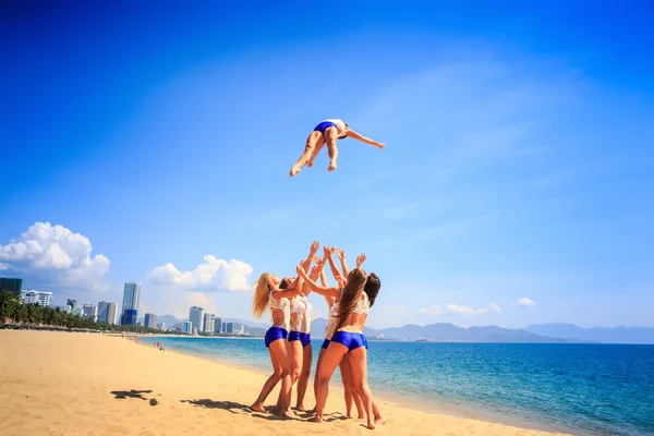 Cheerleaders em branco azul uniforme na praia — Fotografia de Stock