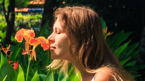 Chica rubia huele flor tropical — Vídeo de stock