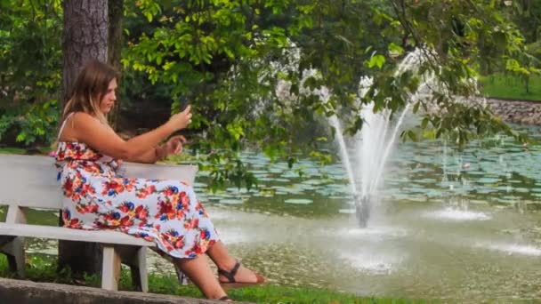 Szőke lány a padon megérinti telefon — Stock videók