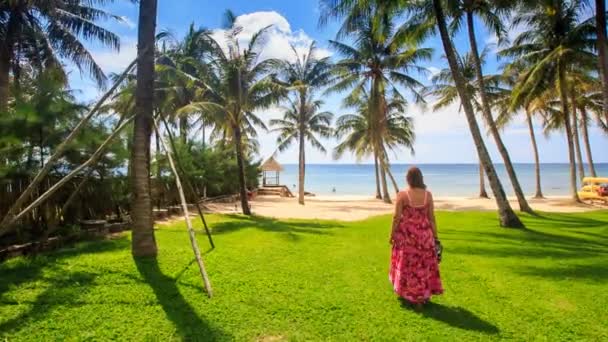 Tjej går till stranden längs grön gräsmatta — Stockvideo