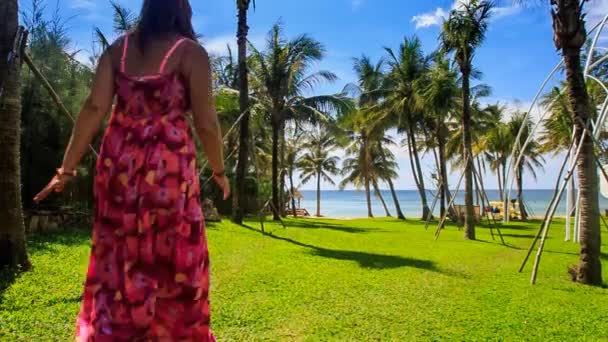 Flickan går till stranden längs grön gräsmatta — Stockvideo