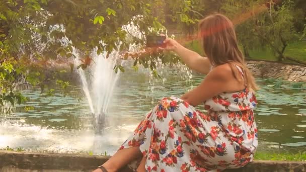 Blondes Mädchen macht Fotos von Brunnen — Stockvideo
