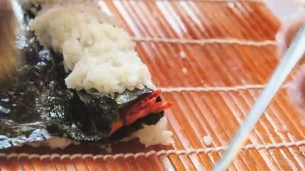 Mains humaines cuisson rouleau de sushi — Video