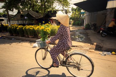 şapkalı Vietnamca kadın bisiklet sürücüleri 