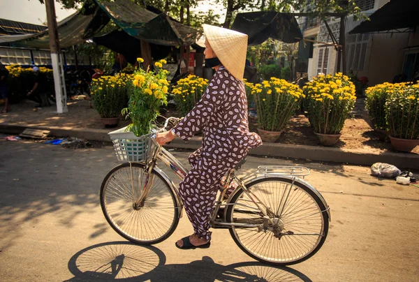 şapkalı Vietnamca kadın bisiklet sürücüleri 