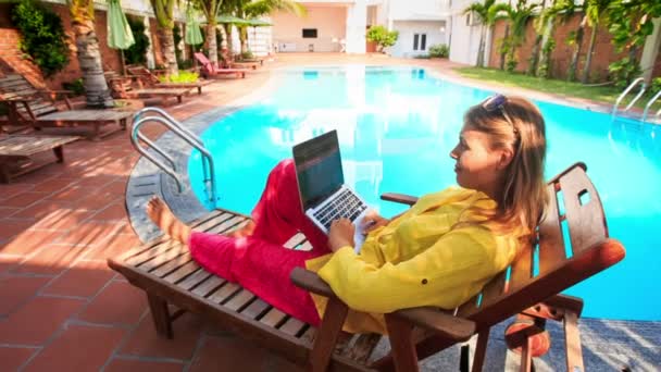 Blond tjej fungerar på Laptop av poolen — Stockvideo