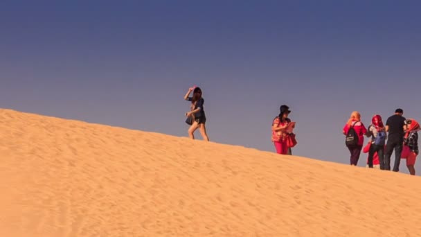 Turistas caminhando no cume das dunas — Vídeo de Stock