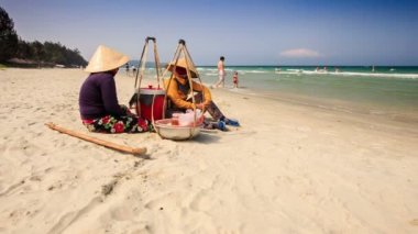 Satıcılar gıda ile kum plajda oturmak 