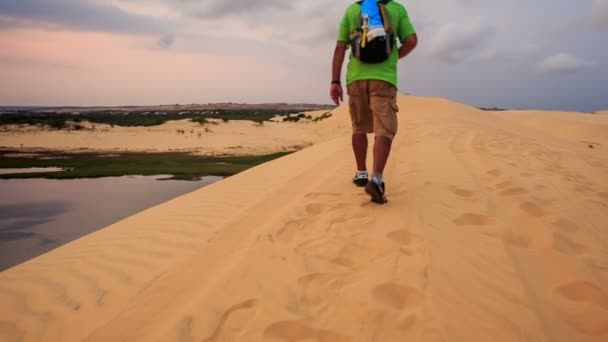 男は砂丘の頂上に沿って歩く — ストック動画