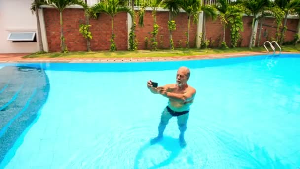 Hombre en piscina hace selfie — Vídeo de stock