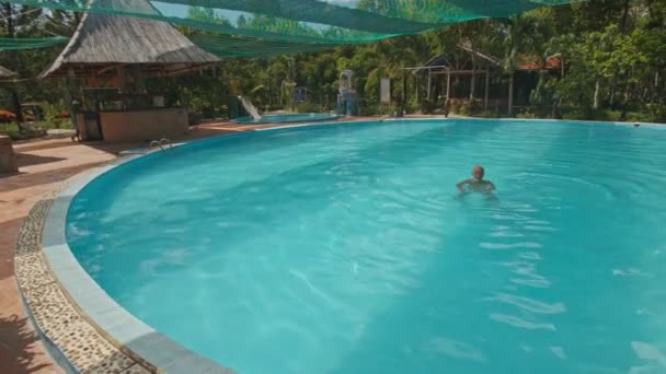 Muž plave v bazénu ovál — Stock video