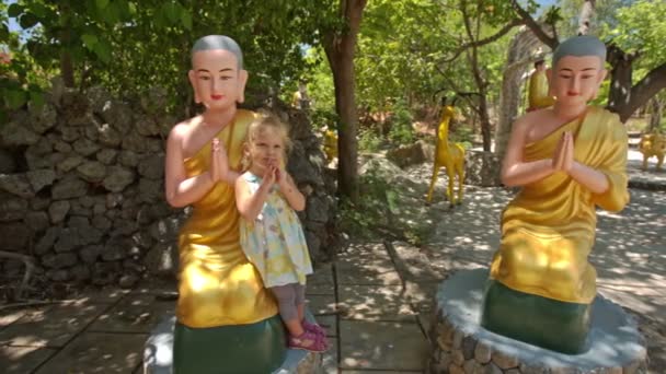 Маленька дівчинка грає на жовтих статуях — стокове відео