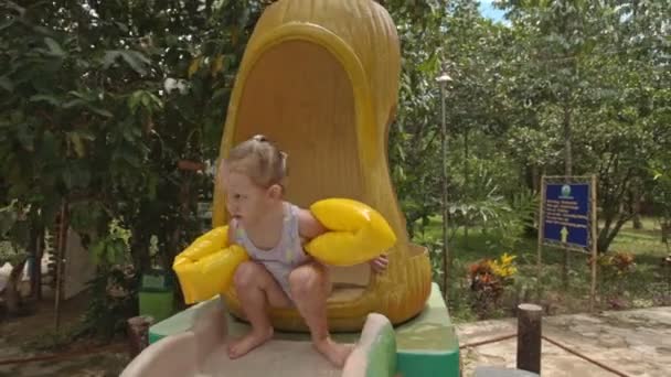 Küçük kız slaytlar aşağı su kaydırağı — Stok video