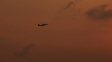 uçağı turuncu bulutların üzerinde uçuyor 