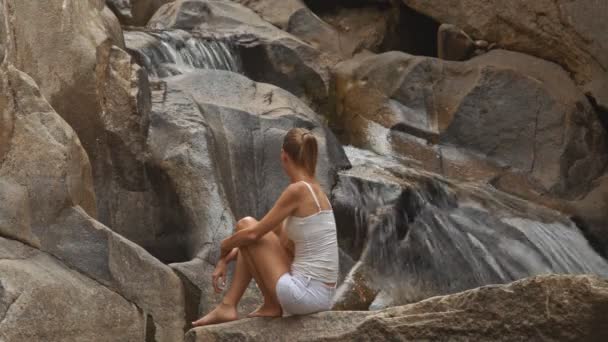 Mädchen praktiziert Yoga in der Nähe von Wasserfall — Stockvideo