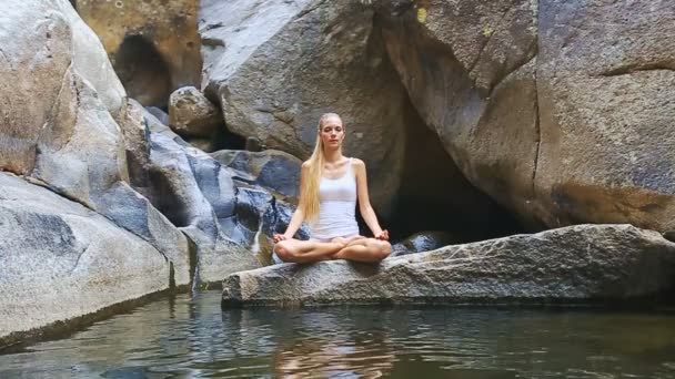 Chica practicando yoga cerca de la cascada — Vídeos de Stock