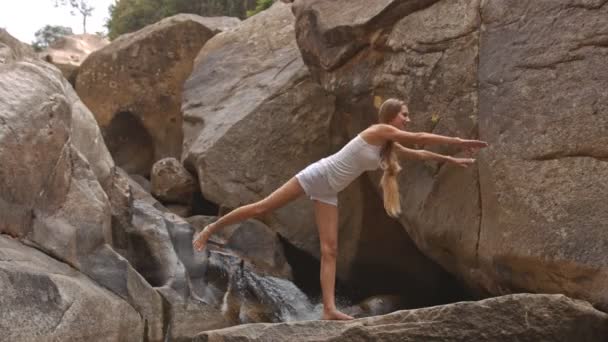 Mädchen praktiziert Yoga in der Nähe von Wasserfall — Stockvideo