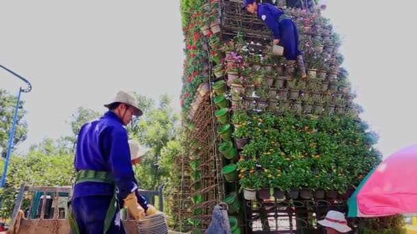 Arbetare konstruera Tower blomsterrabatt — Stockvideo