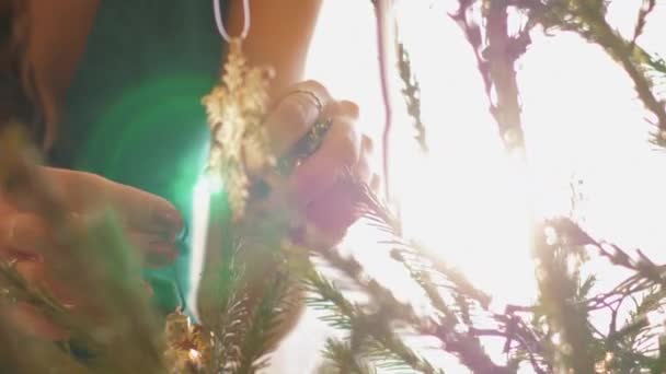 年轻女子的手挂在圣诞树上闪亮的玩具 — 图库视频影像