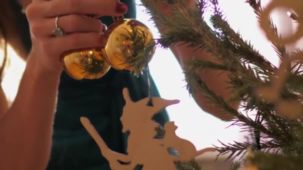 Mulher segura brinquedos de Natal em forma de bola na luz do sol de volta — Vídeo de Stock