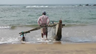 Yerel balıkçı el yapımı balıkçılık inşaatını deniz kıyısına çekti