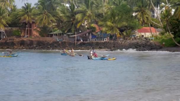 Barcos flotan en la superficie del mar contra la costa con palmas verdes — Vídeo de stock